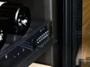 Close-up of a wine fridge shelf with bottles and a control panel. Voir les images du produit