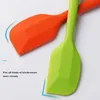 Close-up of two silicone spatulas, one orange and one green, on a white background. Produktbild-Vorschau