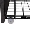 A close-up view of the bottom corner of a bed frame, showing the fabric upholstery, metal frame, and a wheel. Produktbild-Vorschau