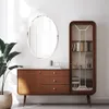 A living room scene featuring a wooden cabinet with a glass display, a mirror, and a plant. Podgląd zdjęcia produktu