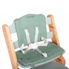 A close-up view of a green baby high chair with a wooden frame and safety straps. Náhľad obrázku produktu