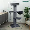 A grey cat tree is shown in a room setting, with a cabinet and a plant in the background. Dimensions are indicated with lines and text. Produktbild-Vorschau