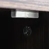A close-up view of the underside of a piece of furniture, showing a metal bracket and a screw with some markings. Produktbild-Vorschau
