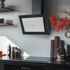 A modern kitchen scene featuring a black and silver range hood above an induction stovetop. Produktbild-Vorschau