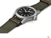 A close-up, angled shot of a Hamilton Khaki Field Mechanical watch with a black dial and a green nylon strap. Podgląd zdjęcia produktu
