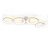 A modern, white LED ceiling light with four interconnected rings, illuminated and mounted on a white ceiling. Voir les images du produit