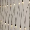 A close-up view of a string of warm white LED lights against a light gray background. Podgląd zdjęcia produktu