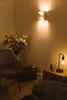 A cozy corner with a chair, flowers, and a lamp. Produktbild-Vorschau