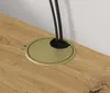 A close-up view of a gold cable grommet with black brush bristles on a wooden surface, with black cables passing through it. Náhled obrázku produktu