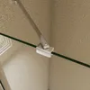 A close-up view of a shower wall bracket and glass panel. Produktbild-Vorschau
