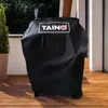 A black grill cover with a logo on it, placed on a wooden deck. Produktbild-Vorschau
