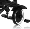 A close-up view of the wheel and pedals of a black children's tricycle. Podgląd zdjęcia produktu