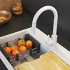 A white kitchen faucet with a pull-out spray is shown over a sink with oranges in a drying rack and a wooden cutting board. Produktbild-Vorschau