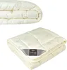 A folded cream-colored duvet with a subtle pattern of sheep and clouds, featuring a grey label with the brand name. Produktbild-Vorschau