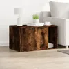 A wooden cabinet with two doors and an open shelf, placed next to a sofa. A lamp, books, and a cup are on top of the cabinet. Náhled obrázku produktu