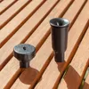 Two black plastic fountain accessories are placed on a wooden slatted surface. Voir les images du produit