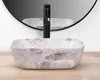 A marble sink with a black faucet is shown in a bathroom setting. Náhled obrázku produktu