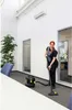 A woman is vacuuming a carpeted office floor with a Kärcher vacuum cleaner. Voir les images du produit
