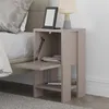 A bedside table next to a bed, with a lamp and an e-reader on top. Produktbild-Vorschau