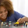A young girl is playing with a LEGO City mining team playset. Produktbild-Vorschau