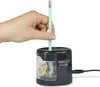 A hand is inserting a pencil into an electric pencil sharpener. Náhled obrázku produktu