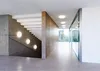A modern interior hallway with a concrete staircase and a glass-walled office space. Produktbild-Vorschau