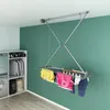 A laundry drying rack is shown hanging from the ceiling in a room with green walls and white ceiling. Podgląd zdjęcia produktu