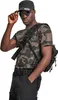 A man wearing a camouflage t-shirt, black cargo pants, a black cap, and sunglasses, posing with a black shoulder bag. Produktbild-Vorschau