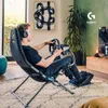 A man playing a racing simulator game in a living room. Anteprima dell’immagine prodotto