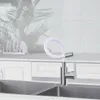 A kitchen faucet with a flexible white hose is shown over a double sink. Produktbild-Vorschau