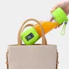 A hand holding a portable blender filled with orange juice, placed inside a tote bag. Náhled obrázku produktu