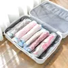 A suitcase filled with vacuum-sealed bags of rolled-up clothing. Voir les images du produit