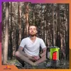 A man meditating in a forest next to a lantern. Podgląd zdjęcia produktu