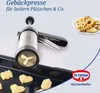 A cookie press and freshly baked cookies are displayed on a baking tray and a plate. Anteprima dell’immagine prodotto
