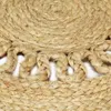 A close-up view of a braided jute rug with fringe details. Podgląd zdjęcia produktu