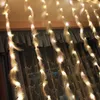 A close-up shot of string lights with feathers hanging in front of curtains. Produktbild-Vorschau