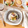 A table setting with plates, food, and drinks. Náhled obrázku produktu