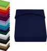 A stack of colorful fitted sheets is shown on the left, and a single dark blue fitted sheet is displayed prominently on the right. Produktbild-Vorschau