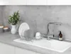A dish drying rack with plates and mugs in a kitchen sink. Anteprima dell’immagine prodotto
