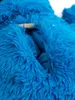 A close-up view of a blue plush backpack with a zipper partially open. Produktbild-Vorschau