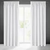 Two white curtains are hung on a rod in front of a window. The window shows greenery outside. Produktbild-Vorschau