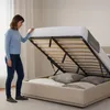 A woman is demonstrating the storage feature of a bed frame. Produktbild-Vorschau