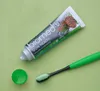 A tube of toothpaste and a toothbrush are placed on a light green surface. Voir les images du produit