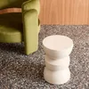 A cream-colored side table next to a green armchair on a speckled floor. Produktbild-Vorschau