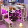 A loft bed with a desk and shelves underneath, set up in a bedroom with decorative lighting. Produktbild-Vorschau