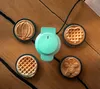 A mint green mini waffle maker with interchangeable plates sits on a wooden table, surrounded by four freshly made waffles. The waffles are in various shapes: a pumpkin, a classic waffle, a gingerbread man, and another classic waffle. Anteprima dell’immagine prodotto