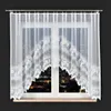 A white lace curtain with a floral pattern hangs in a window at night, with city lights visible outside. Produktbild-Vorschau