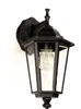 A black outdoor wall lamp with a clear glass enclosure and a visible light bulb, mounted on a white wall. Podgląd zdjęcia produktu