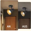 A split image showing a black ceiling light fixture with a gold interior, both on and off, against a backdrop of wooden doors. Náhľad obrázku produktu