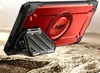 A red and black tablet case with a kickstand is displayed on a sandy, rocky surface. Náhled obrázku produktu